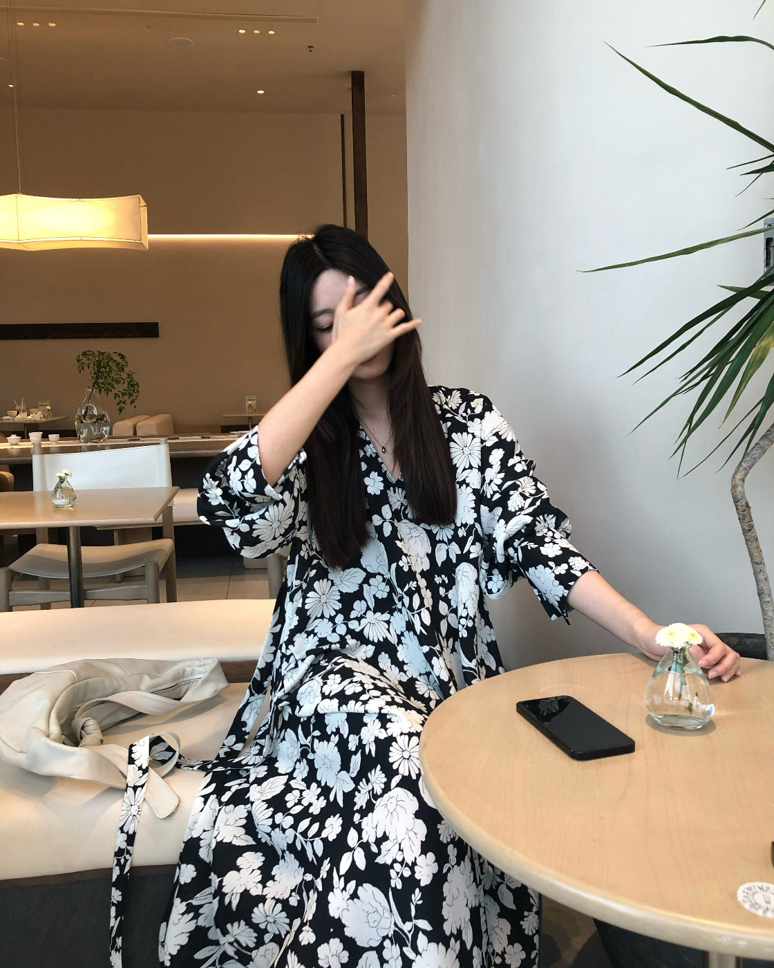 A loose-fitting long-sleeved floral dress with a slimming waist design