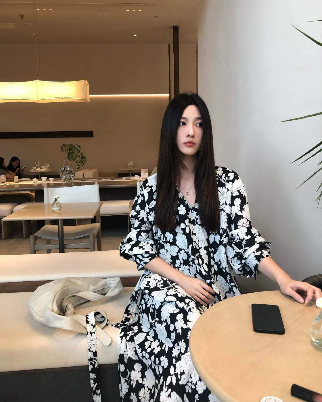 A loose-fitting long-sleeved floral dress with a slimming waist design