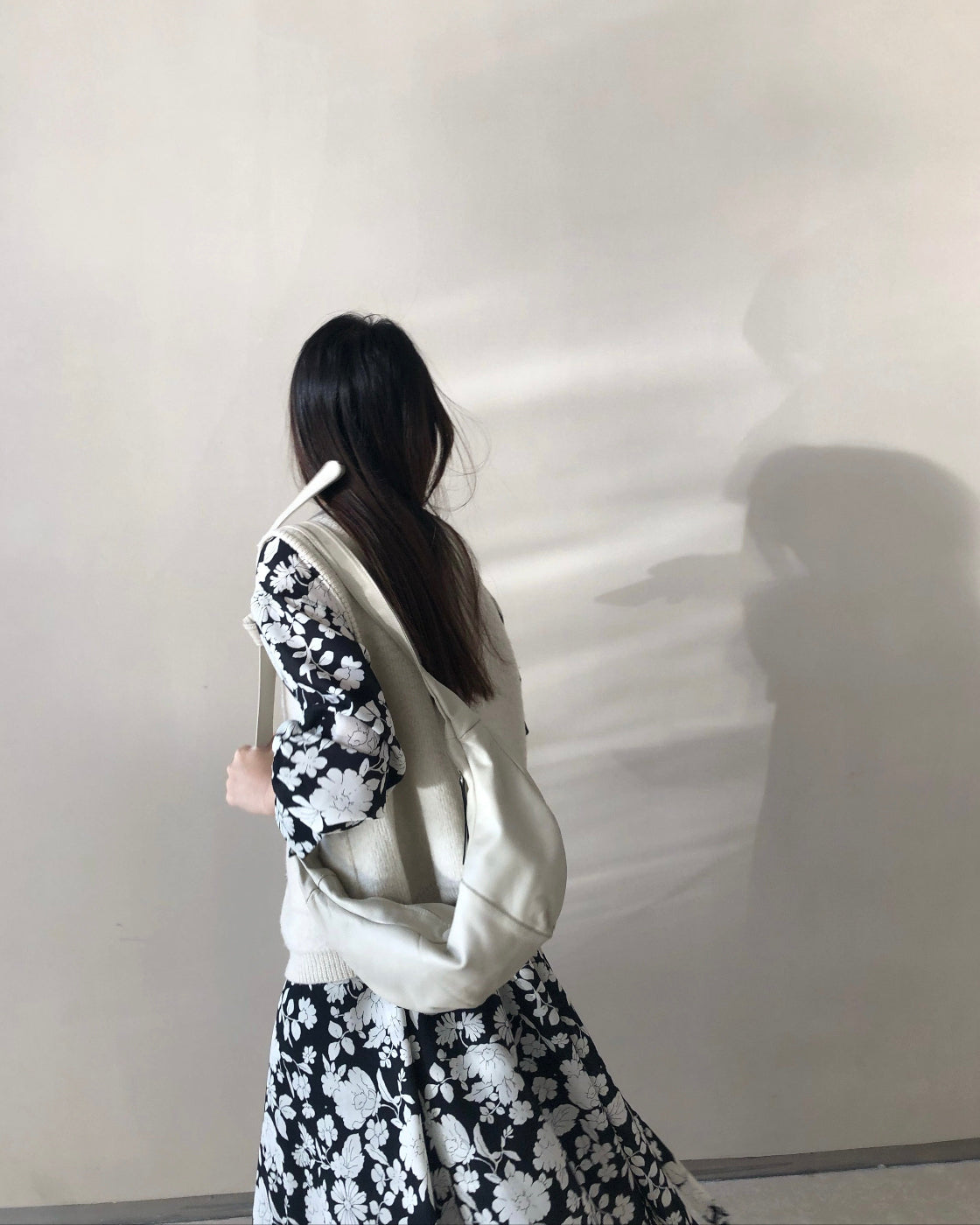 A loose-fitting long-sleeved floral dress with a slimming waist design