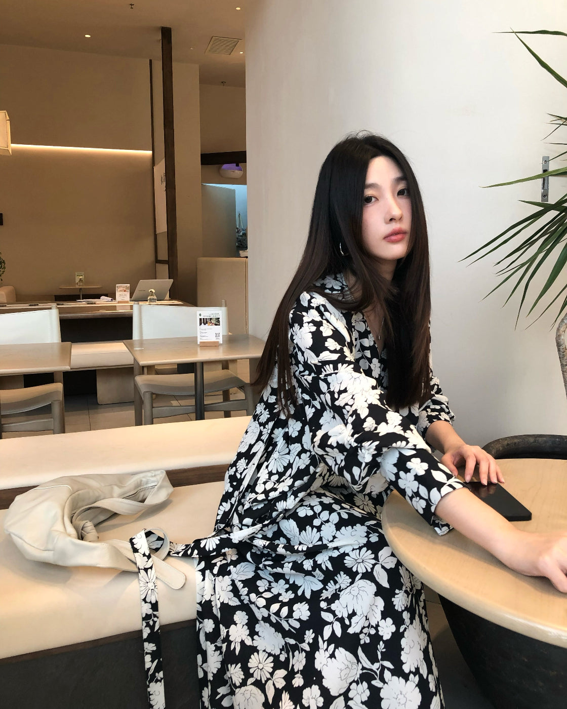 A loose-fitting long-sleeved floral dress with a slimming waist design