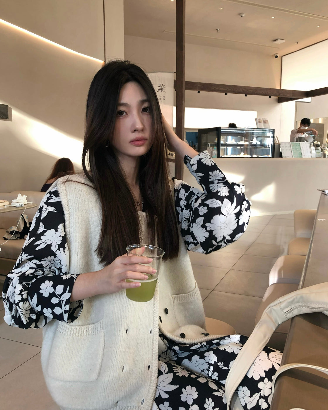 A loose-fitting long-sleeved floral dress with a slimming waist design